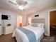 Inviting bedroom with a comfortable bed, ceiling fan, mounted TV, and doorway access to the bathroom at 8101 Cane Pointe Ln, Waxhaw, NC 28173
