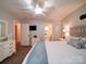 Bright bedroom featuring a comfortable bed, ceiling fan, a mounted TV, and convenient access to an en-suite bathroom at 8101 Cane Pointe Ln, Waxhaw, NC 28173