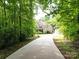 Long, paved driveway leads to a two-story brick home with a detached garage nestled in a lush, green setting at 8101 Cane Pointe Ln, Waxhaw, NC 28173