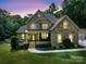 Charming brick home featuring a manicured lawn, inviting front porch, and professional landscaping at 8101 Cane Pointe Ln, Waxhaw, NC 28173