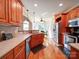 A warm kitchen with wood floors, cherry cabinets, stainless appliances and view of the breakfast nook at 8101 Cane Pointe Ln, Waxhaw, NC 28173