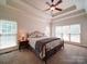 Large main bedroom featuring large windows, neutral carpet, and bedside tables with lamps at 8101 Cane Pointe Ln, Waxhaw, NC 28173