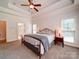 Spacious main bedroom with tray ceiling, large bed, neutral carpet, and bedside tables with lamps at 8101 Cane Pointe Ln, Waxhaw, NC 28173