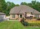 Brick home with a wooden deck perfect for entertaining with outdoor furniture and umbrella in a landscaped yard at 8101 Cane Pointe Ln, Waxhaw, NC 28173