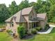 An aerial view of the brick home highlighting the back patio, and lush yard with mature trees at 8101 Cane Pointe Ln, Waxhaw, NC 28173