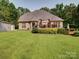 Charming brick home with a wooden deck, lush landscaping, and a detached garage on a large lot at 8101 Cane Pointe Ln, Waxhaw, NC 28173
