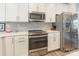 Bright kitchen features white cabinets, stainless steel appliances, herringbone backsplash, and quartz countertops at 819 Anderson St, Charlotte, NC 28205