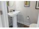 Modern powder room with a pedestal sink, brushed nickel faucet, and decorative art at 819 Anderson St, Charlotte, NC 28205