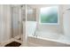 Well-lit bathroom featuring a soaking tub and glass shower enclosure, perfect for relaxation and convenience at 9285 Swimming Dr, Harrisburg, NC 28075