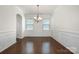 Formal dining room with hardwood floors, elegant chandelier, and wainscoting, perfect for hosting dinner parties at 9285 Swimming Dr, Harrisburg, NC 28075