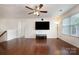 Spacious living room featuring hardwood floors, a ceiling fan, and large window, perfect for entertaining and relaxation at 9285 Swimming Dr, Harrisburg, NC 28075