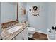 Charming powder room with a decorative mirror and granite countertop at 9928 Raddington Ln, Charlotte, NC 28269