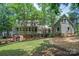 Backyard view showcasing the multi-story home, deck, screened porch, and mature trees at 9928 Raddington Ln, Charlotte, NC 28269