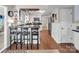 Bright kitchen with white cabinetry, hardwood floors, modern lighting, and a breakfast bar at 9928 Raddington Ln, Charlotte, NC 28269