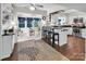 Eat-in kitchen with white cabinets, stainless steel appliances, black countertop and view to sunroom at 9928 Raddington Ln, Charlotte, NC 28269