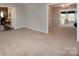 Spacious living room with neutral walls, carpet, and open access to other rooms at 9928 Raddington Ln, Charlotte, NC 28269