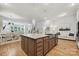 Open-concept kitchen with island, hardwood floors, and seamless flow to dining and living areas at 10022 Wayfair Meadow Ct, Charlotte, NC 28277