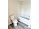 Clean bathroom featuring a white toilet, a tiled shower-tub and laminate flooring at 1012 4Th St, Statesville, NC 28677