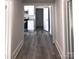 Hallway with view of updated kitchen featuring laminate flooring and white cabinetry at 1012 4Th St, Statesville, NC 28677