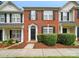 Charming brick-front townhome featuring manicured landscaping and black shutters at 10867 Garden Oaks Ln, Charlotte, NC 28273