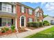 Brick townhome with manicured landscaping, sidewalk, and covered porch at 10867 Garden Oaks Ln, Charlotte, NC 28273