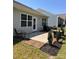 Cozy back patio featuring neutral colors, brick accents, lush green grass, and a small table with chairs and grill at 110 White Apple Way, Statesville, NC 28625