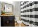 Stylish bathroom with granite counter, dark cabinetry, decorative mirror and black and white striped shower curtain at 11070 River Oaks Nw Dr, Concord, NC 28027