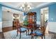 Stylish dining room featuring a dark wood table, blue accents, and a decorative hutch for storage at 11070 River Oaks Nw Dr, Concord, NC 28027