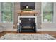 Living room fireplace with a wood beam mantel, stone surround, and television above at 11070 River Oaks Nw Dr, Concord, NC 28027