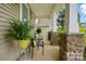 Cozy front porch with stone pillars, comfortable seating, and decorative plants for a welcoming entry at 11070 River Oaks Nw Dr, Concord, NC 28027