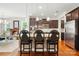 Modern kitchen island with seating, pendant lighting, and dark cabinetry with stainless steel appliances at 11070 River Oaks Nw Dr, Concord, NC 28027