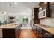 Open kitchen with island, granite countertops, stainless steel appliances, hardwood floors, and view of the dining room at 11070 River Oaks Nw Dr, Concord, NC 28027