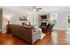 Comfortable living room with a fireplace, hardwood floors, and leather furniture at 11070 River Oaks Nw Dr, Concord, NC 28027
