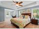 Bright main bedroom with a floral bedding, ceiling fan, and an office space attached to the side at 11070 River Oaks Nw Dr, Concord, NC 28027