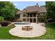 Backyard with outdoor fireplace, swimming pool, stone patio, and mature trees at 1108 Shinnecock Ln, Waxhaw, NC 28173