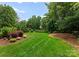 Lush backyard with manicured lawn and mature trees; creating a private and serene setting at 1108 Shinnecock Ln, Waxhaw, NC 28173