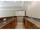 A modern bar with granite countertops and wooden cabinets at 1108 Shinnecock Ln, Waxhaw, NC 28173