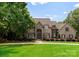 Elegant stone-and-stucco home with manicured lawn, mature trees, and lush landscaping at 1108 Shinnecock Ln, Waxhaw, NC 28173