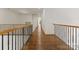Wood hallway with a carpeted landing showcasing railing design and natural light at 1108 Shinnecock Ln, Waxhaw, NC 28173
