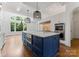 Gourmet kitchen boasts a blue island, stainless appliances, and hardwood floors at 1108 Shinnecock Ln, Waxhaw, NC 28173
