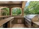 Covered outdoor kitchen features a stainless steel grill, stone countertops, and backyard views at 1108 Shinnecock Ln, Waxhaw, NC 28173