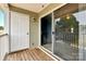 Outdoor balcony with wood floors, sliding glass doors, white siding, and a white entry door at 1134 Plaza Walk Dr, Charlotte, NC 28215