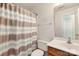 Bathroom featuring a wood vanity, toilet, and a shower with a striped shower curtain, with neutral color scheme at 1134 Plaza Walk Dr, Charlotte, NC 28215