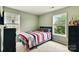 Neutral-toned bedroom featuring a twin bed between two windows, enhanced by natural light, and a built-in desk at 1134 Plaza Walk Dr, Charlotte, NC 28215