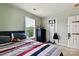 Neutral-toned bedroom with a twin bed between two windows, a black dresser, and sports decor at 1134 Plaza Walk Dr, Charlotte, NC 28215