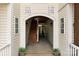 Inviting entrance with classic archway, exposed wood stairs, and charming potted plants, welcomes you home at 1134 Plaza Walk Dr, Charlotte, NC 28215