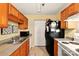Efficient kitchen featuring wood cabinets, stainless steel sink, and modern appliances at 1134 Plaza Walk Dr, Charlotte, NC 28215