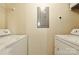Bright laundry room features a washer and dryer with electrical panels, providing a convenient space for laundry care at 1134 Plaza Walk Dr, Charlotte, NC 28215