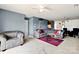 Comfortable living room with carpet, chair, grey sofa, glass table, with views into the dining area at 1134 Plaza Walk Dr, Charlotte, NC 28215