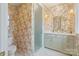 Bright bathroom with butterfly wallpaper, marble floors, decorative lighting, and frosted glass shower door at 1172 Queens Rd, Charlotte, NC 28207